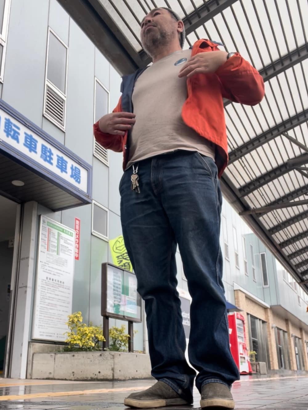 オレンジ系のマウンテンパーカー、ブルー系のデニムパンツ、ベージュ系のその他シューズを着用したメンズの春コーディネートの3枚目の写真