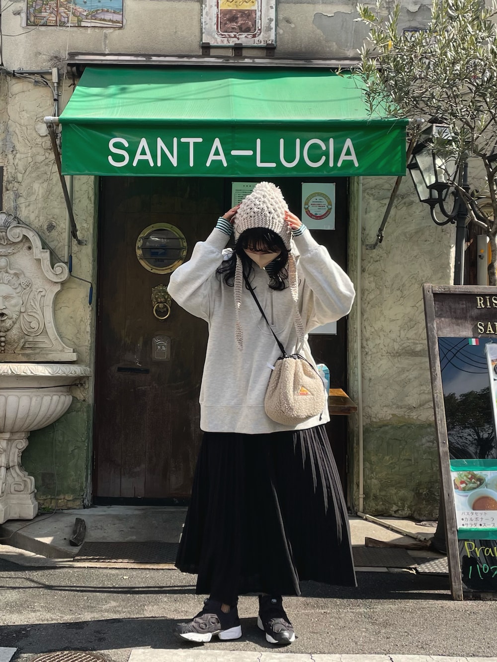 ブラック系のショルダーバッグ、ブラック系のスカート、ブラック系のスニーカーを着用したレディースの冬コーディネートの2枚目の写真