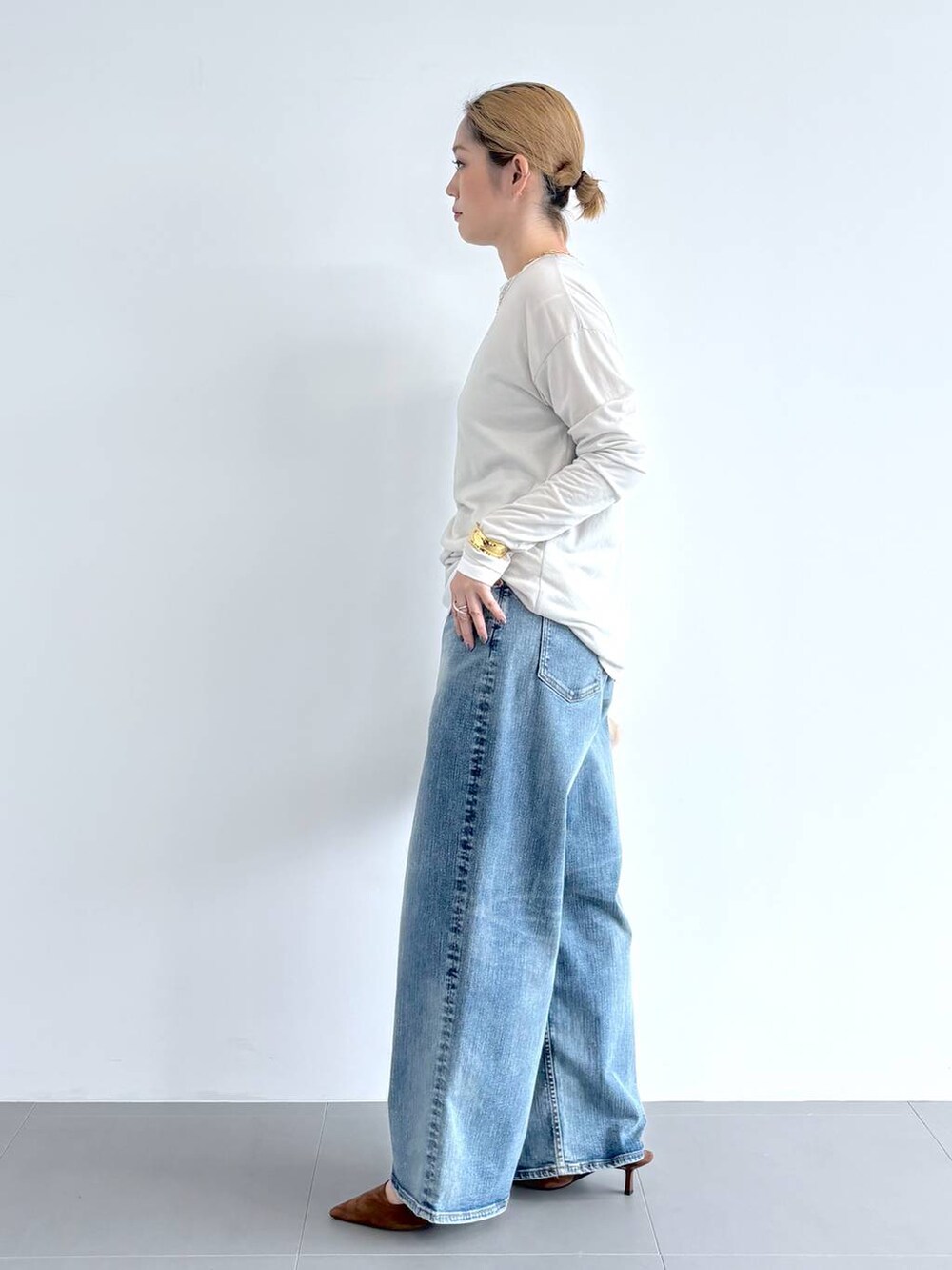 ブルー系のデニムパンツ、ホワイト系のショルダーバッグ、ホワイト系のTシャツ/カットソーを着用したレディースの夏コーディネートの3枚目の写真