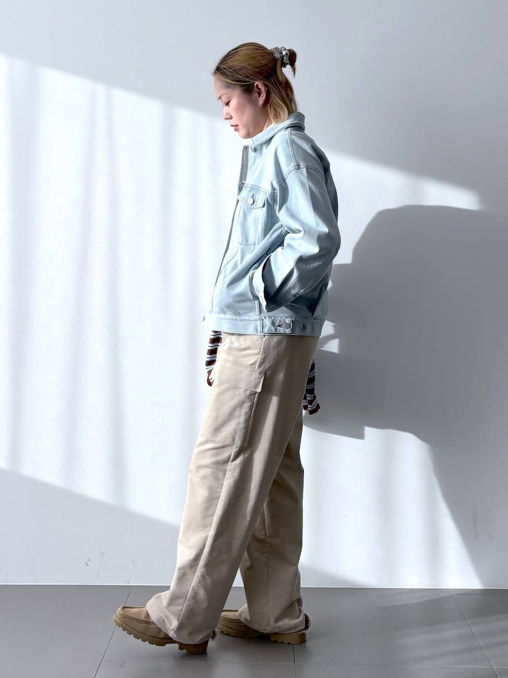 イエロー系のボストンバッグ、ホワイト系のTシャツ/カットソー、ベージュ系のローファーを着用したレディースの冬コーディネートの6枚目の写真