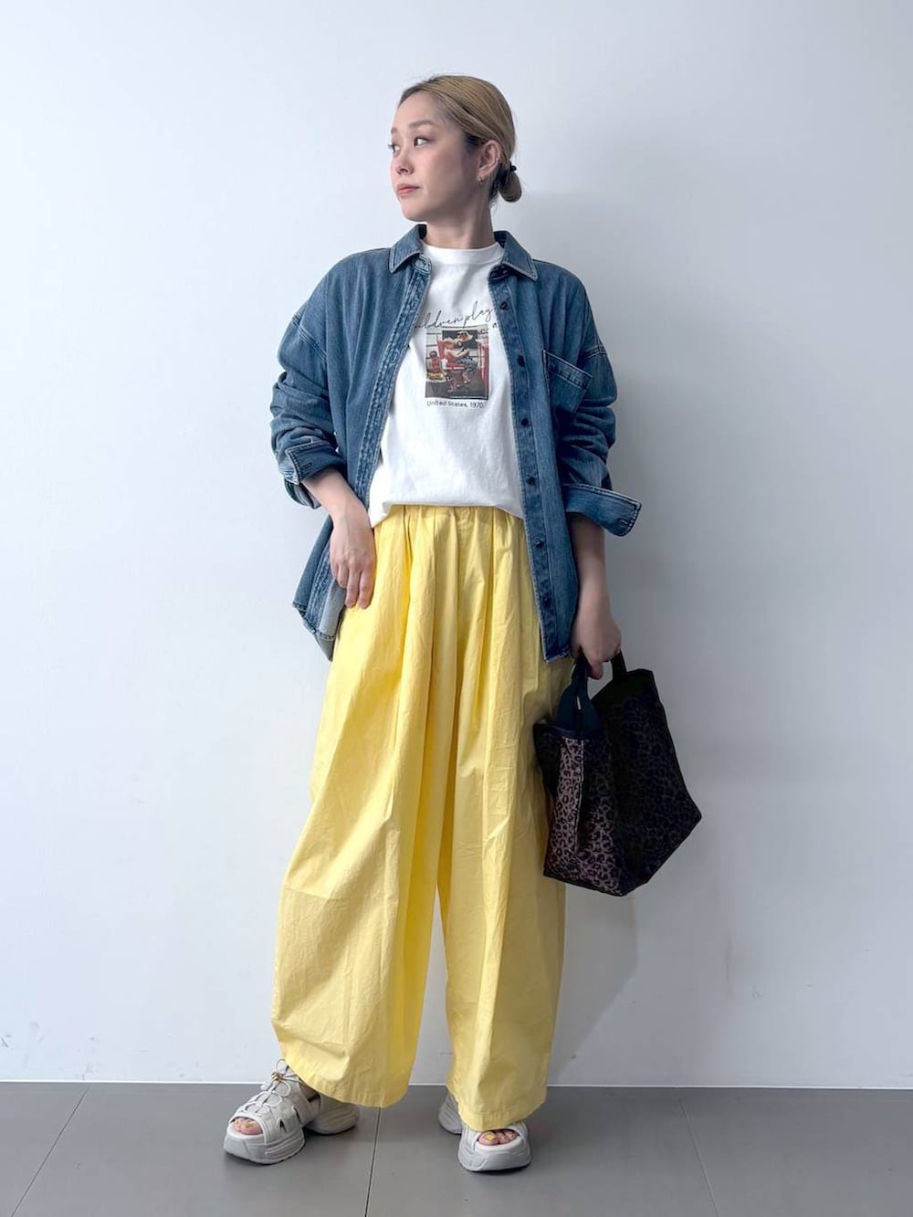 イエロー系のその他パンツ、ブルー系のシャツ/ブラウス、その他のトートバッグを着用したレディースの春コーディネートの2枚目の写真