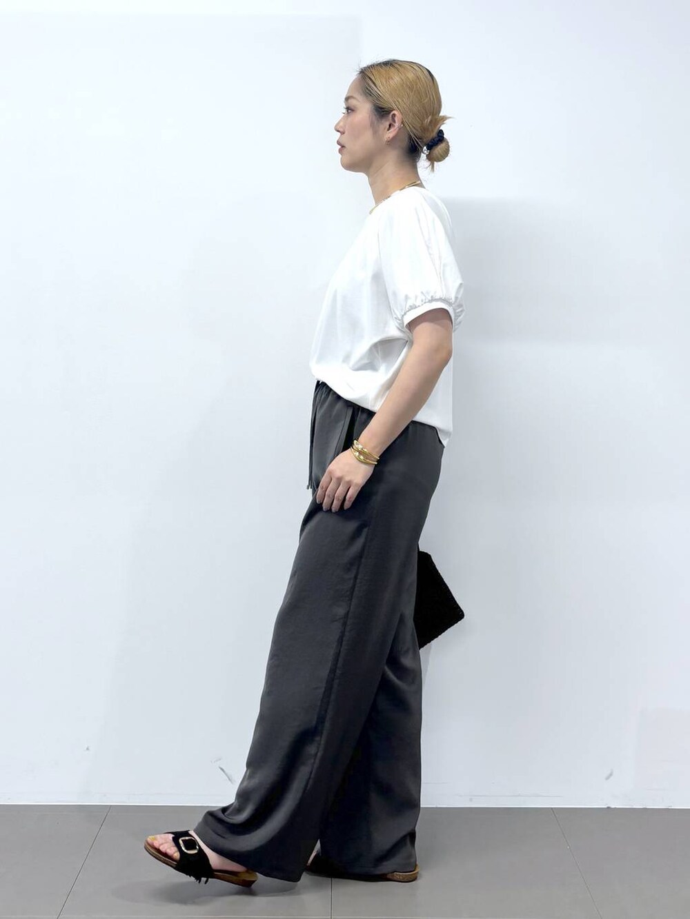 グレー系のその他パンツ、ホワイト系のTシャツ/カットソー、ブラック系のサンダルを着用したレディースの春コーディネートの7枚目の写真