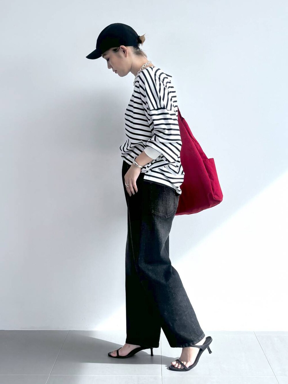 ブラック系のスリッポン、ホワイト系のTシャツ/カットソー、レッド系のトートバッグを着用したレディースの夏コーディネートの3枚目の写真