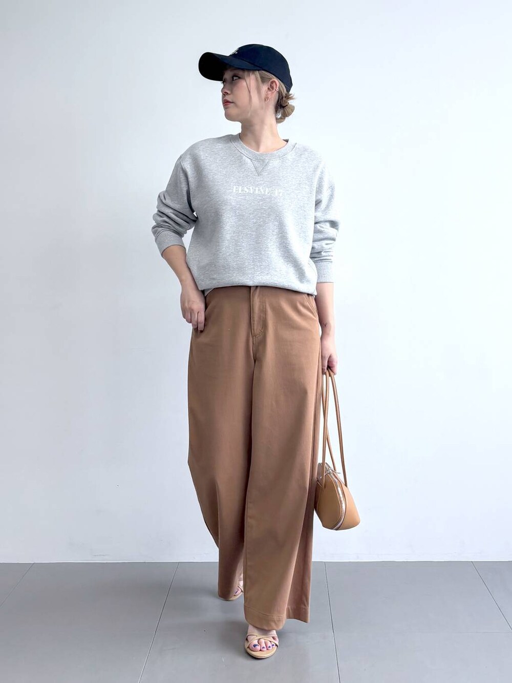 ベージュ系のニット/セーター、グレー系のスウェット、イエロー系のその他パンツを着用したレディースの冬コーディネートの5枚目の写真