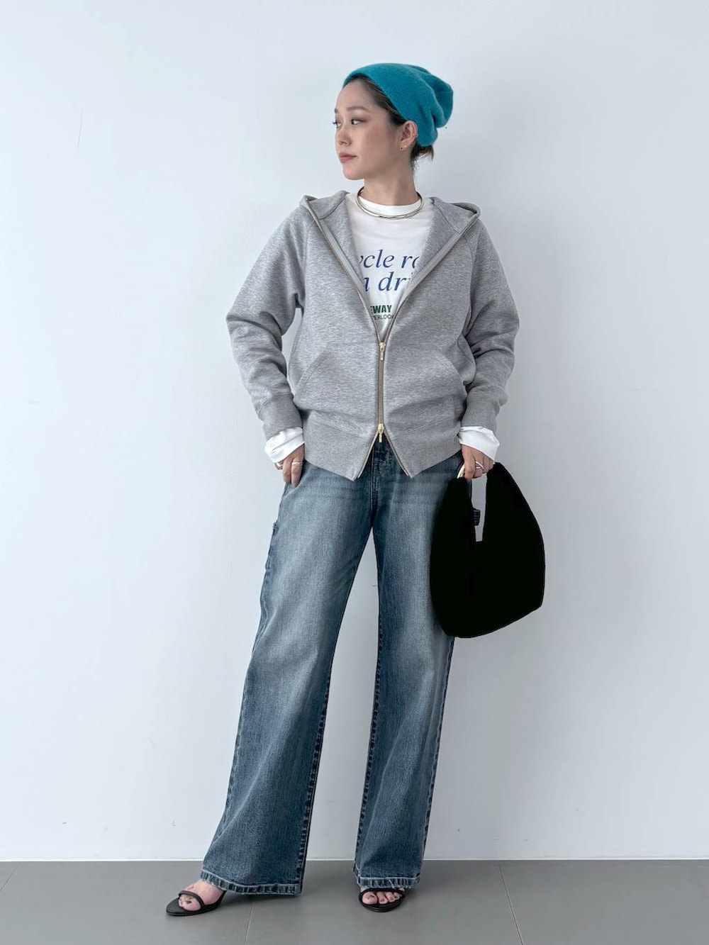 ブラック系のスリッポン、ブラック系のトートバッグ、ブルー系のデニムパンツを着用したレディースの秋コーディネートの2枚目の写真