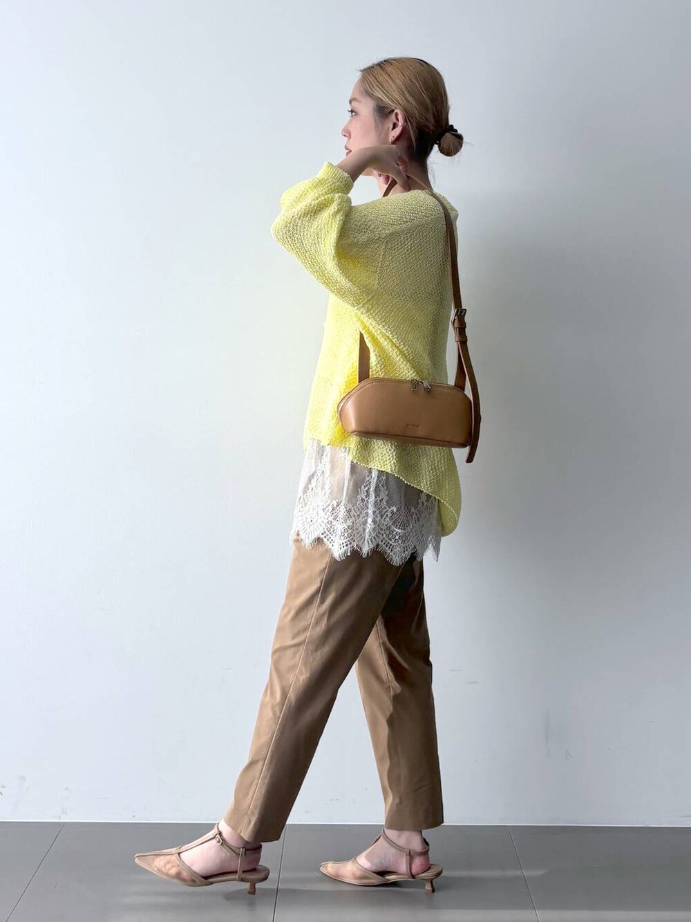 イエロー系のカーディガン/ボレロ、ベージュ系のその他パンツ、ブラウン系のショルダーバッグを着用したレディースの春コーディネートの2枚目の写真