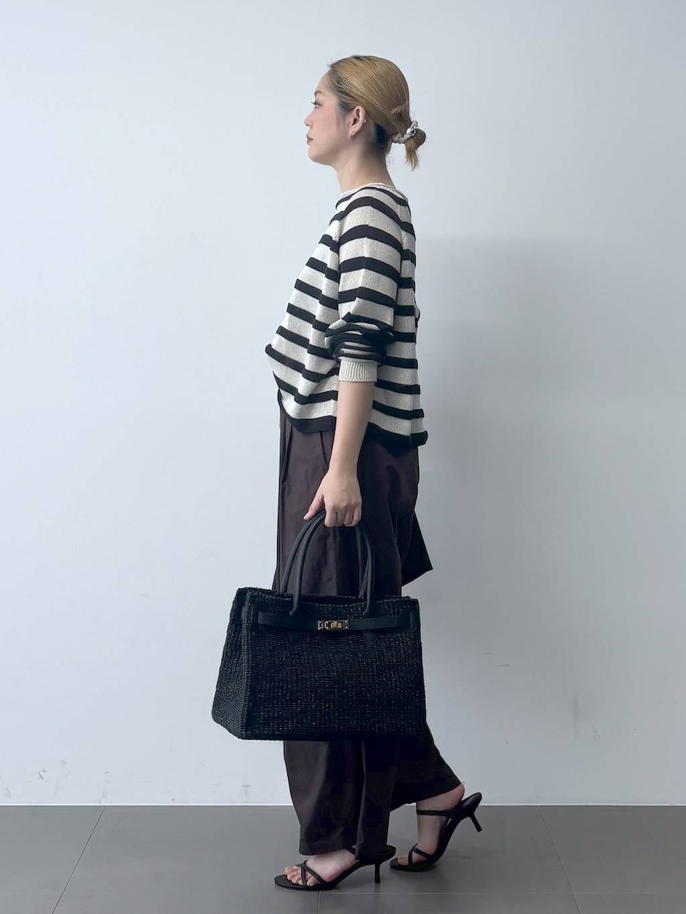 ブラウン系のその他パンツ、ベージュ系のニット/セーター、ブラック系のテーラードジャケットを着用したレディースの春コーディネートの4枚目の写真