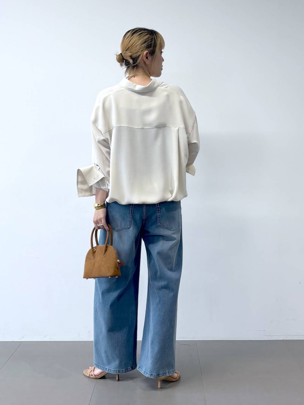 ブルー系のデニムパンツ、ベージュ系のサンダル、ホワイト系のシャツ/ブラウスを着用したレディースの夏コーディネートの6枚目の写真