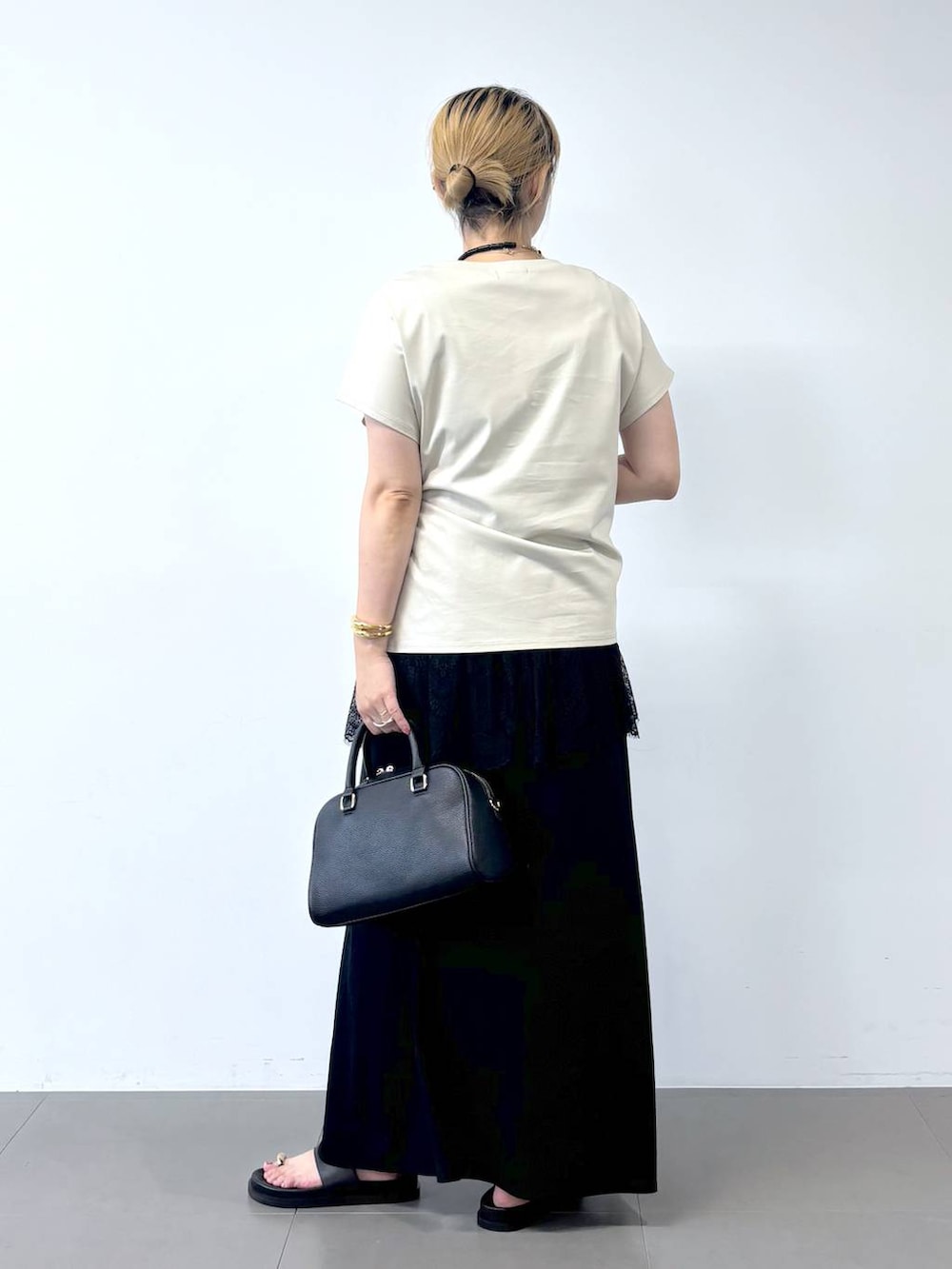 グレー系のTシャツ/カットソー、ブラック系のボストンバッグ、ブラック系のサンダルを着用したレディースの夏コーディネートの6枚目の写真