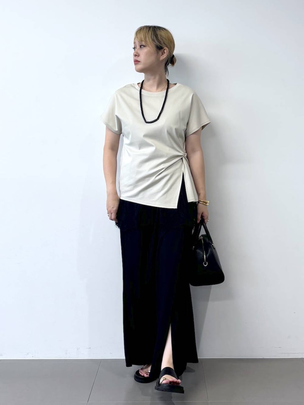 グレー系のTシャツ/カットソー、ブラック系のボストンバッグ、ブラック系のサンダルを着用したレディースの夏コーディネートの2枚目の写真