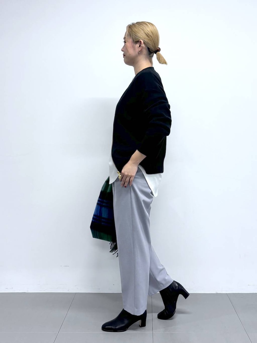 ブラック系のハンドバッグ、ブラック系のブーツ、ブラック系のカーディガン/ボレロを着用したレディースの秋コーディネートの4枚目の写真