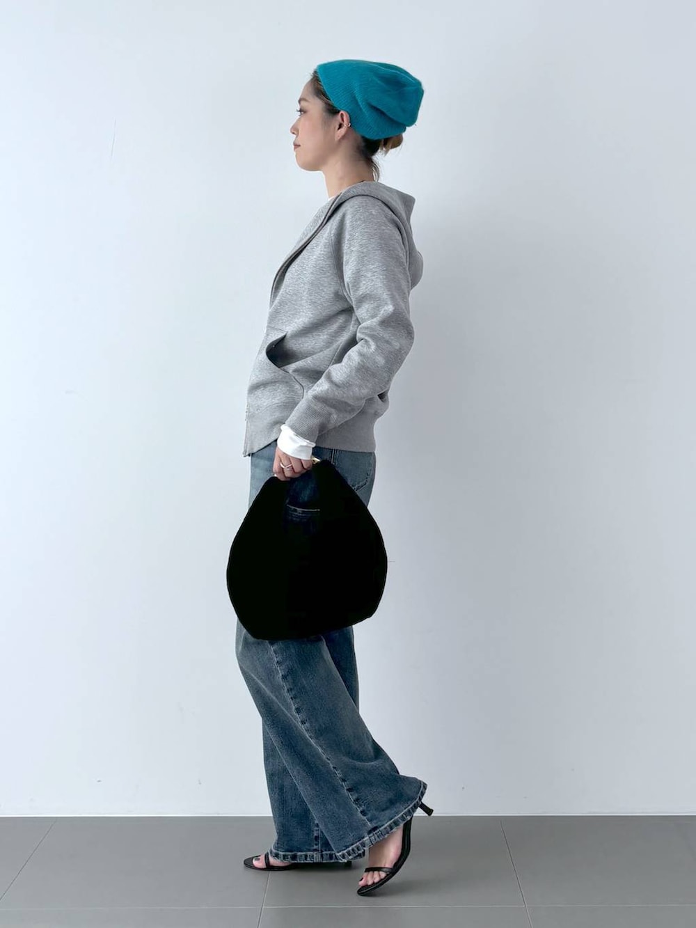 ブラック系のスリッポン、ブラック系のトートバッグ、ブルー系のデニムパンツを着用したレディースの秋コーディネートの3枚目の写真