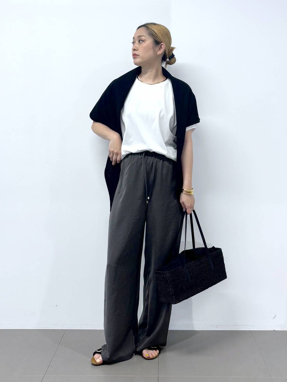 グレー系のその他パンツ、ホワイト系のTシャツ/カットソー、ブラック系のサンダルを着用したレディースの春コーディネートの3枚目の写真
