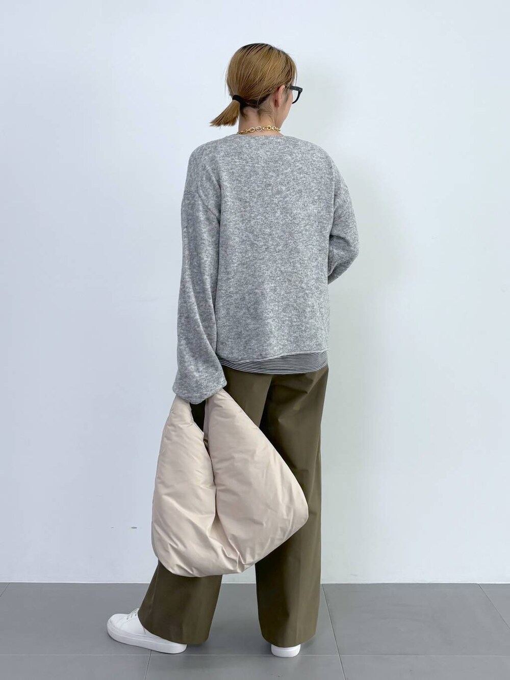 ブラック系のブルゾン、ホワイト系のスニーカー、グレー系のニット/セーターを着用したレディースの秋コーディネートの8枚目の写真