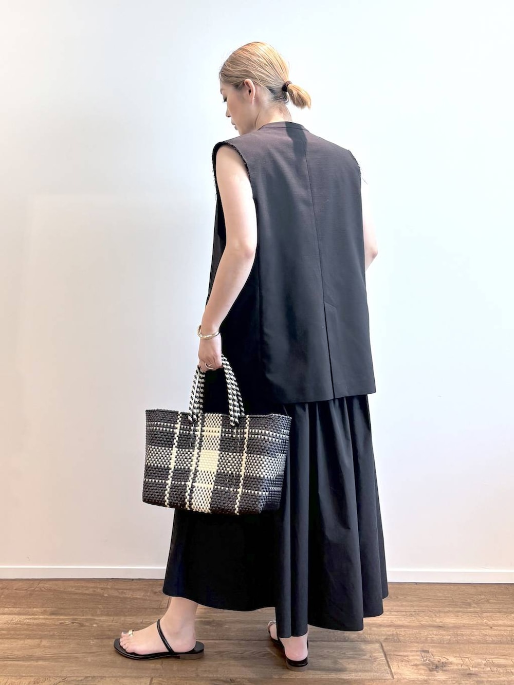 その他のトートバッグ、ブラック系のワンピース、ブラック系のベストを着用したレディースの春コーディネートの3枚目の写真