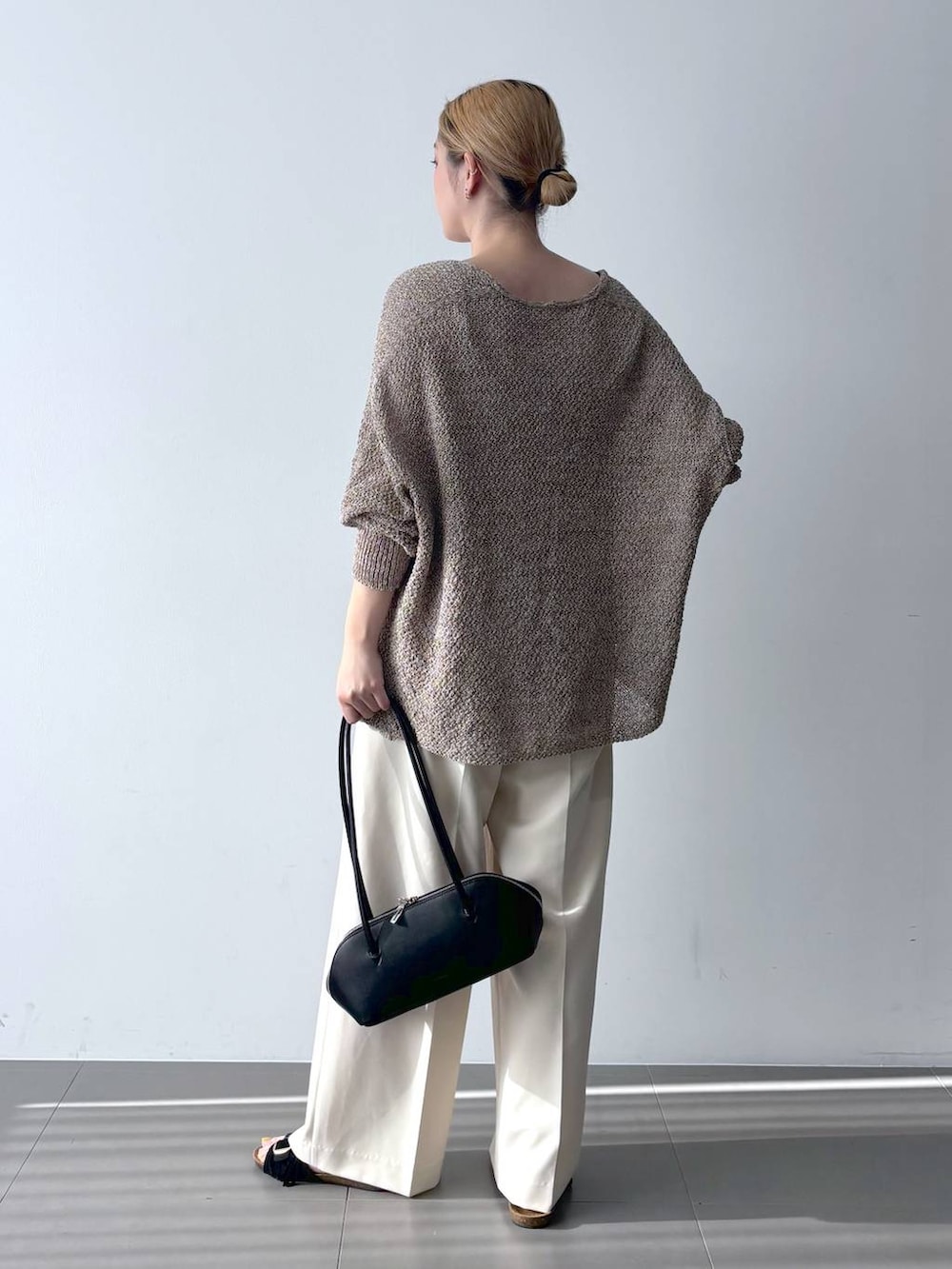 ブラウン系のカーディガン/ボレロ、ブラック系のハンドバッグ、ホワイト系のその他パンツを着用したレディースの春コーディネートの5枚目の写真