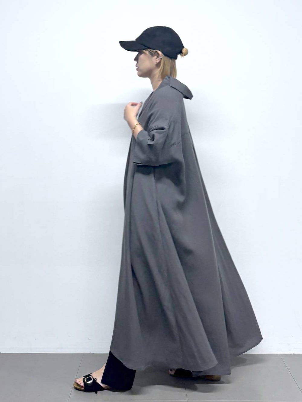 ブラック系のボストンバッグ、ブラック系のサンダル、グレー系のワンピースを着用したレディースの夏コーディネートの3枚目の写真