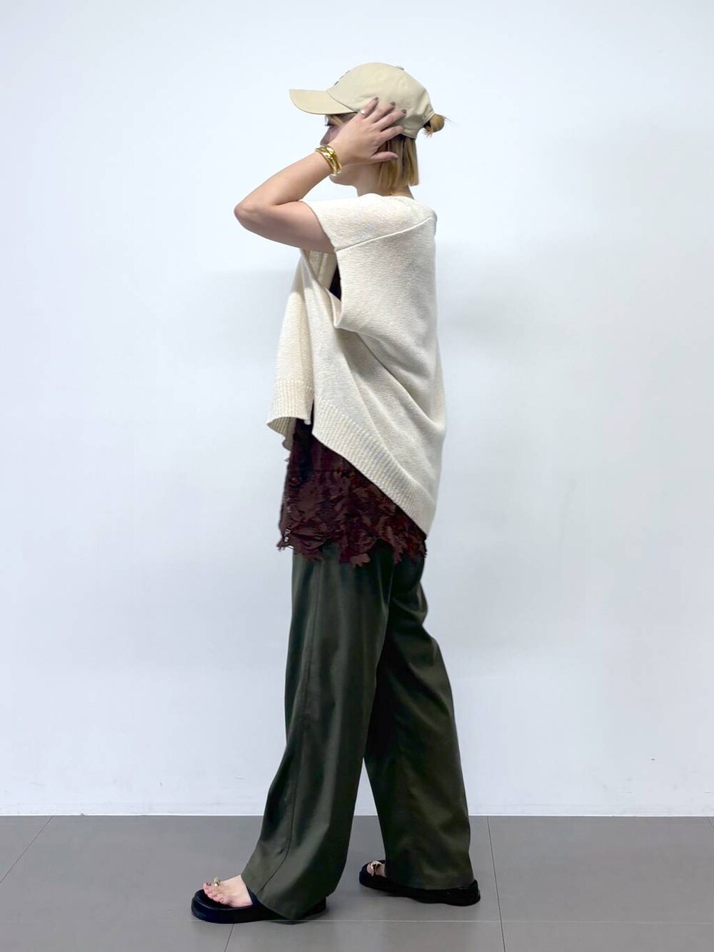 グリーン系のチノパンツ、ホワイト系のショルダーバッグ、ブラック系のサンダルを着用したレディースの夏コーディネートの4枚目の写真