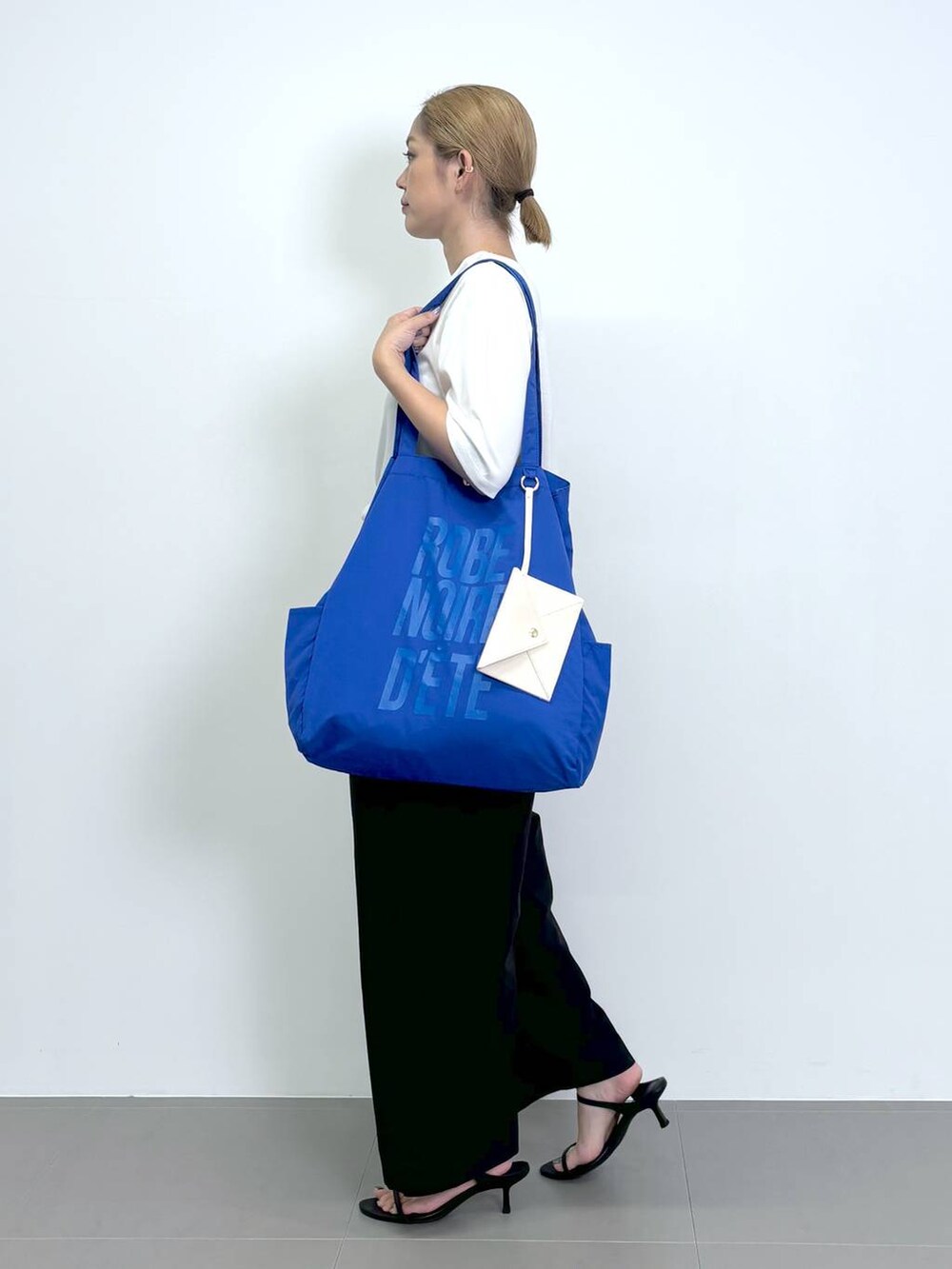 ブラック系のスリッポン、ブラック系のその他パンツ、ホワイト系のTシャツ/カットソーを着用したレディースの夏コーディネートの2枚目の写真