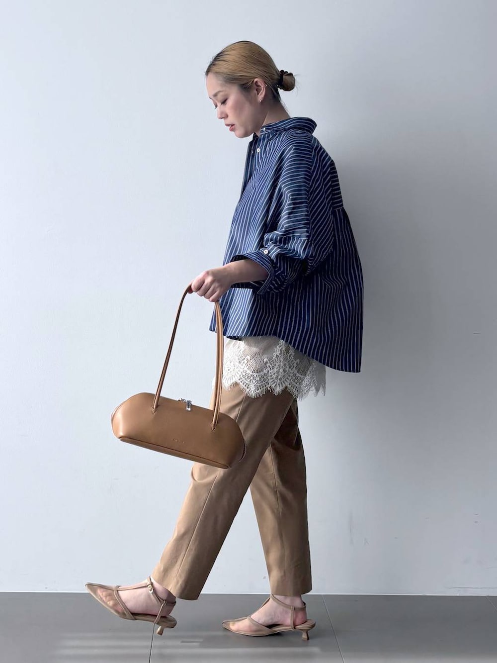 ブルー系のシャツ/ブラウス、ブラウン系のハンドバッグ、ベージュ系のその他パンツを着用したレディースの春コーディネートの3枚目の写真