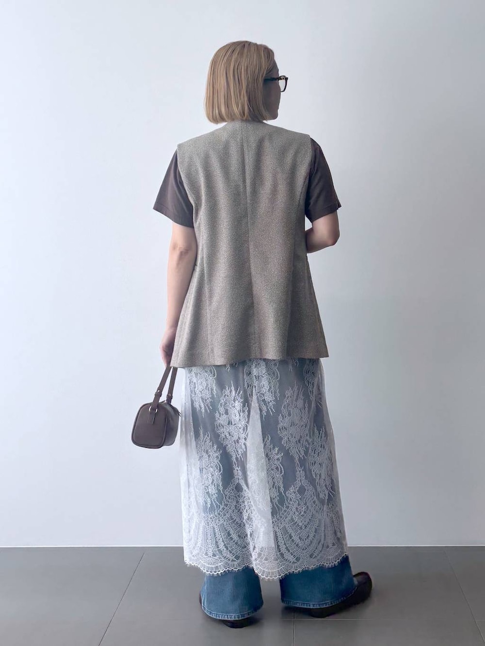 ブラウン系のハンドバッグ、ブラウン系のローファー、グレー系のTシャツ/カットソーを着用したレディースの夏コーディネートの4枚目の写真