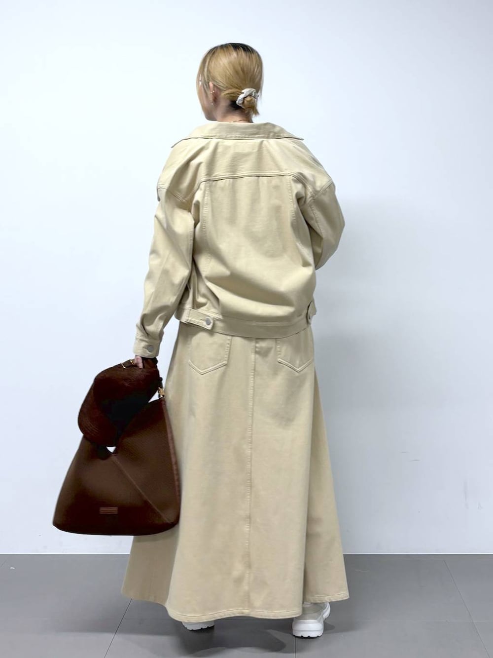 ブラウン系のTシャツ/カットソー、ベージュ系のスカート、ベージュ系のデニムジャケットを着用したレディースの冬コーディネートの4枚目の写真