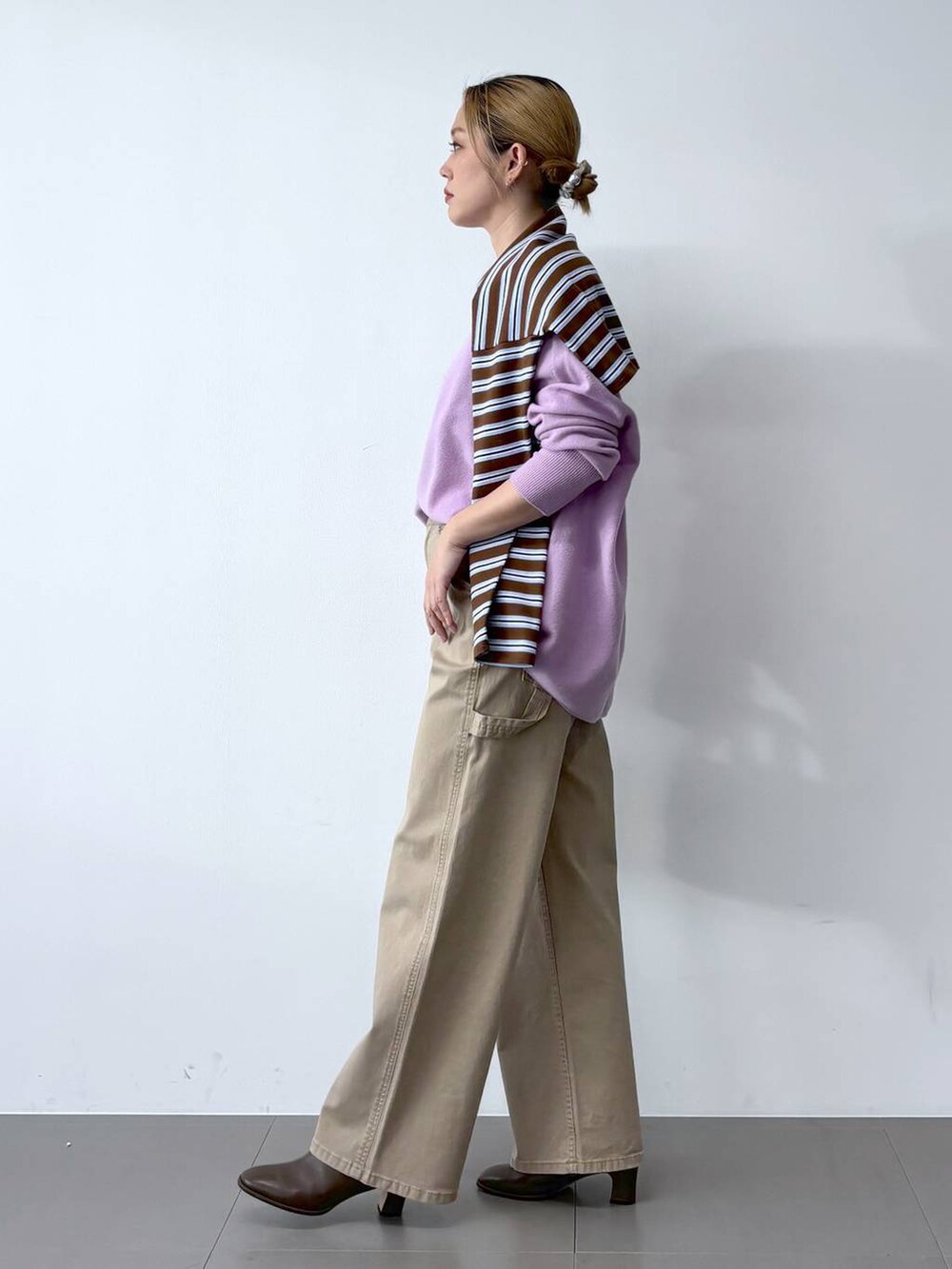 ブラウン系のブーツ、パープル系のニット/セーター、ブラウン系のTシャツ/カットソーを着用したレディースの冬コーディネートの3枚目の写真