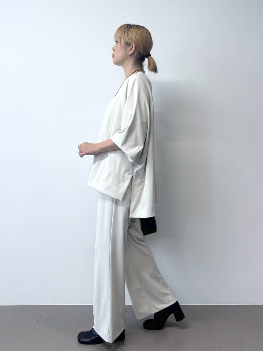 ブラック系のボストンバッグ、ブラック系のその他アウター、ホワイト系のTシャツ/カットソーを着用したレディースの秋コーディネートの8枚目の写真