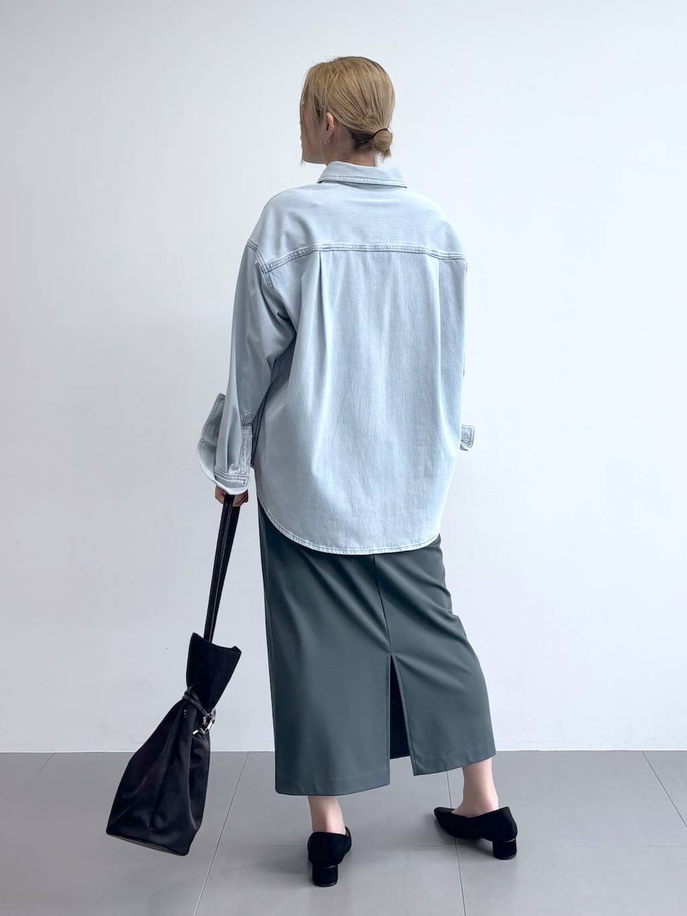 ブルー系のシャツ/ブラウス、ブラック系のニット/セーター、ブラック系のパンプスを着用したレディースの冬コーディネートの6枚目の写真