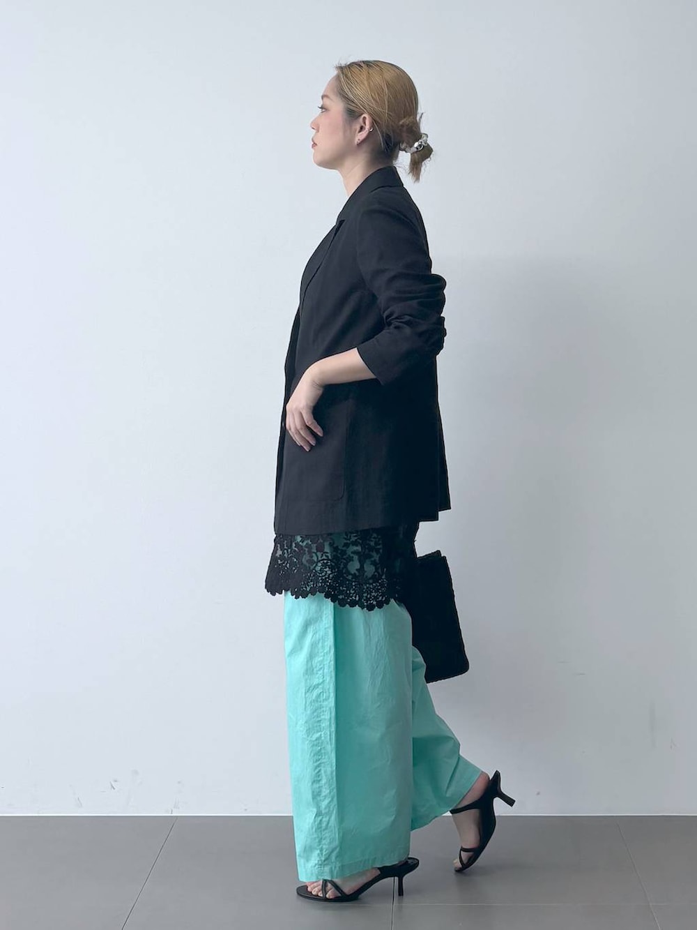 ブルー系のその他パンツ、ブラック系のテーラードジャケット、ブラック系のかごバッグを着用したレディースの春コーディネートの3枚目の写真