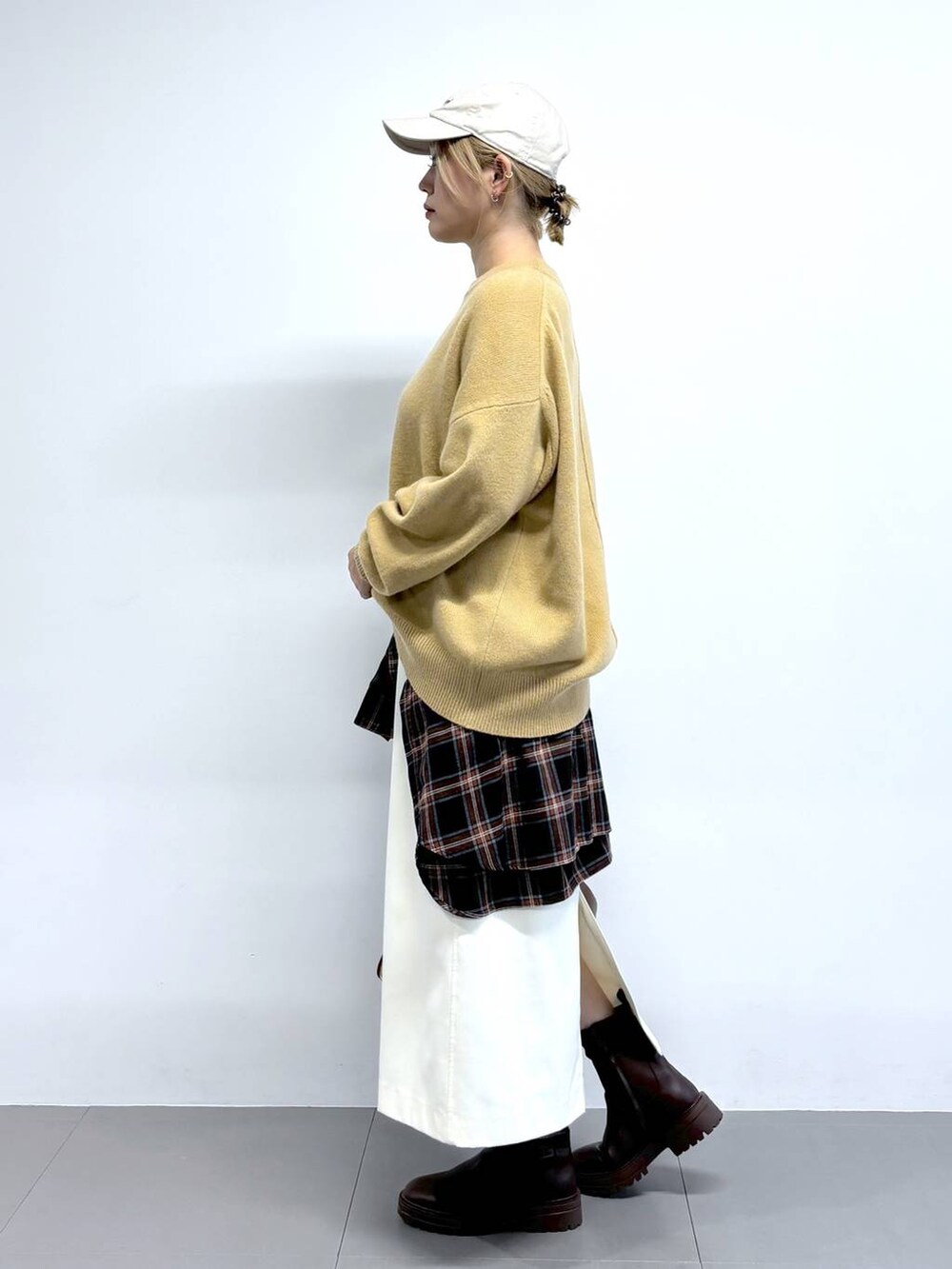 ブラウン系のトートバッグ、ホワイト系のスカート、ベージュ系のニット/セーターを着用したレディースの秋コーディネートの3枚目の写真