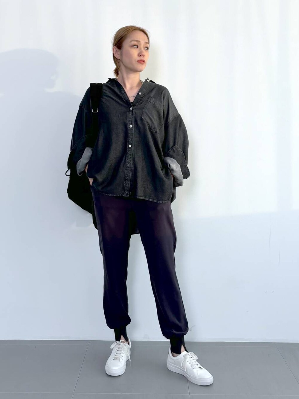 ブラック系のバックパック/リュック、グレー系のシャツ/ブラウス、グレー系のその他パンツを着用したレディースの春コーディネートの2枚目の写真