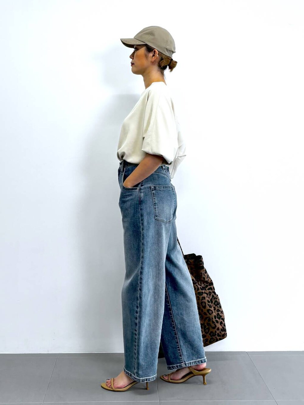 ベージュ系のスリッポン、ホワイト系のシャツ/ブラウス、ブルー系のデニムパンツを着用したレディースの夏コーディネートの4枚目の写真