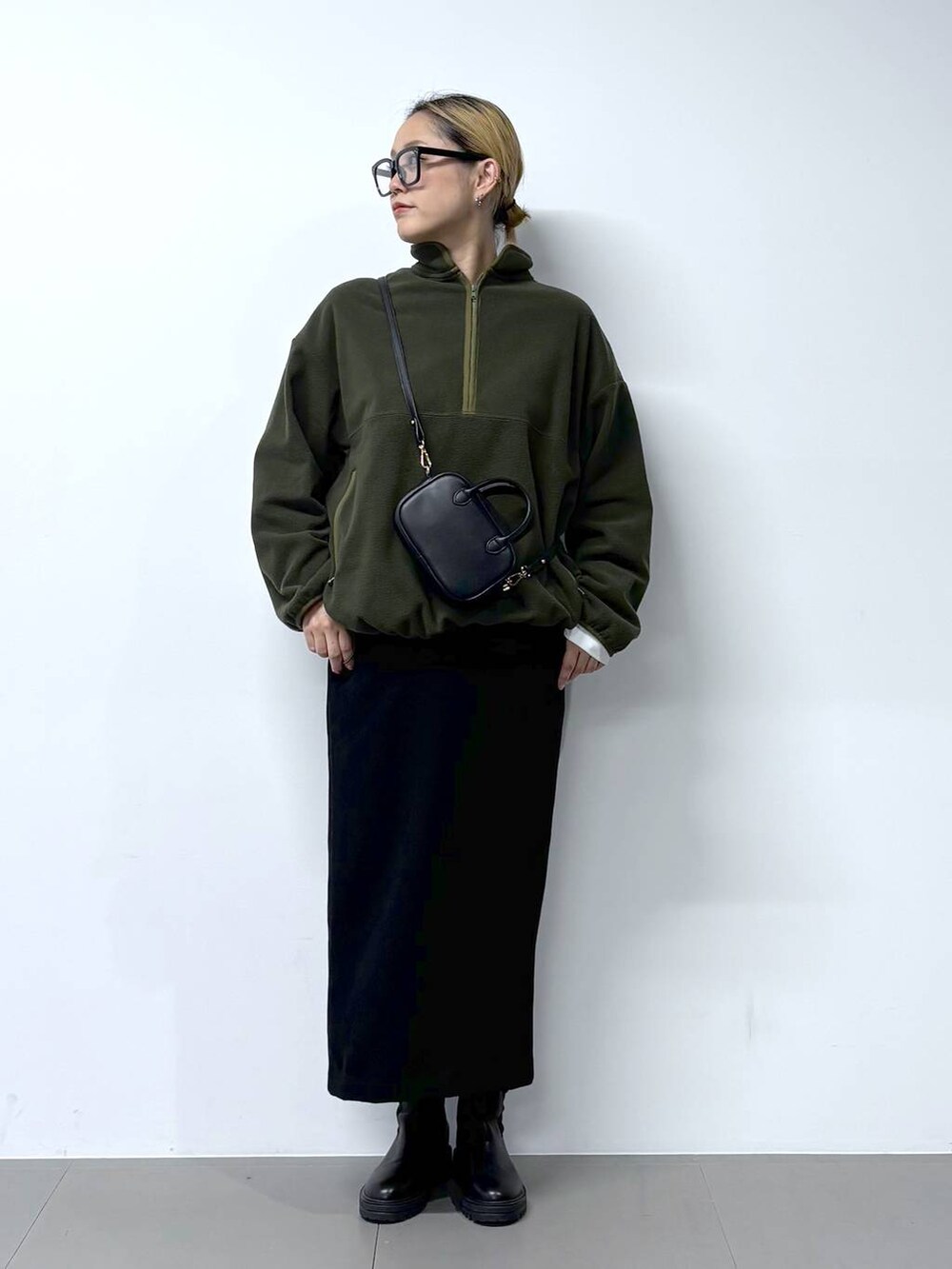 ブラック系のブーツ、ホワイト系のTシャツ/カットソー、ブラック系のショルダーバッグを着用したレディースの秋コーディネートの2枚目の写真