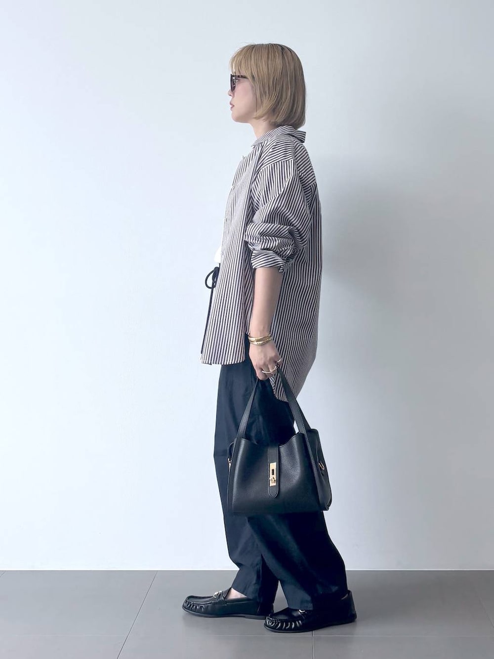 ブラック系のローファー、ブルー系のカーゴパンツ、ホワイト系のTシャツ/カットソーを着用したレディースの秋コーディネートの3枚目の写真