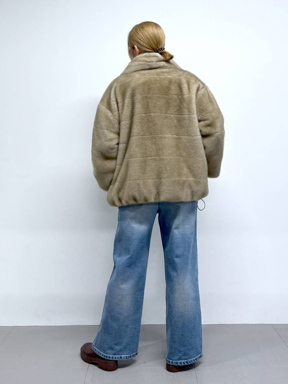 ブルー系のデニムパンツ、ブラウン系のニット/セーター、ブラウン系のショルダーバッグを着用したレディースの秋コーディネートの3枚目の写真