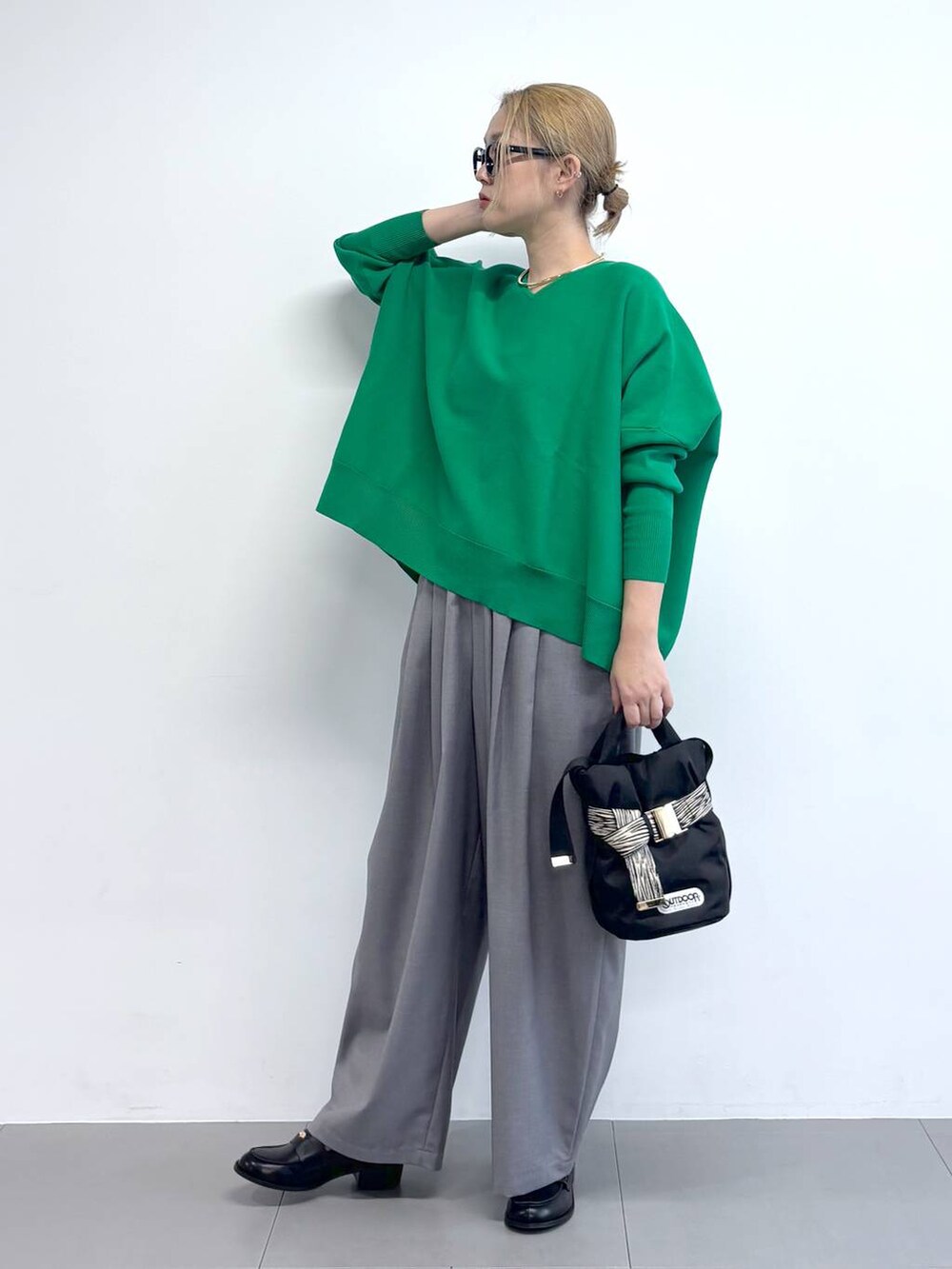 グリーン系のニット/セーター、グレー系のその他パンツ、その他のショルダーバッグを着用したレディースの冬コーディネートの4枚目の写真