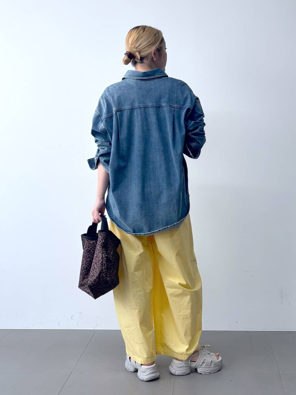 イエロー系のその他パンツ、ブルー系のシャツ/ブラウス、その他のトートバッグを着用したレディースの春コーディネートの5枚目の写真