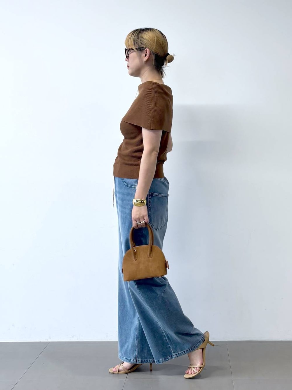 ブルー系のデニムパンツ、ベージュ系のサンダル、ブラウン系のニット/セーターを着用したレディースの夏コーディネートの3枚目の写真