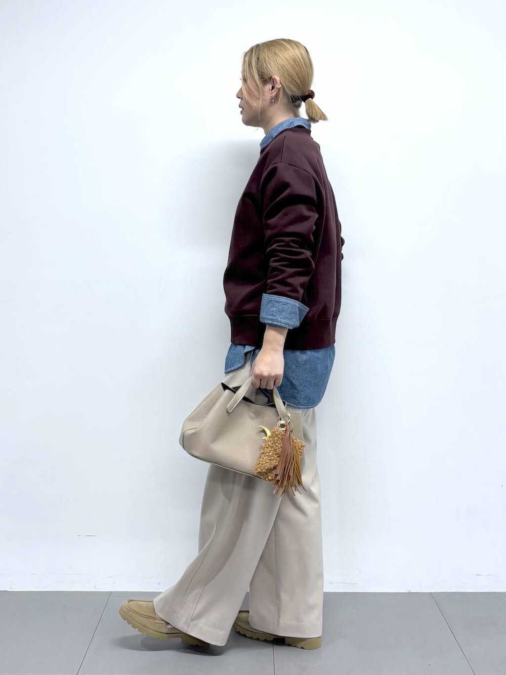 ベージュ系のローファー、レッド系のスウェット、ベージュ系のその他パンツを着用したレディースの秋コーディネートの2枚目の写真