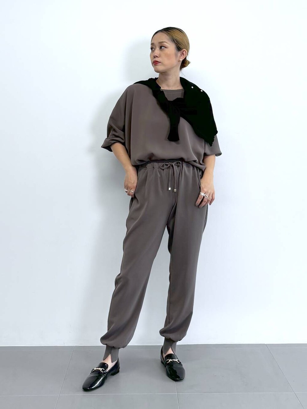 ブラック系のレインシューズ、グレー系のトートバッグ、ブラウン系のその他パンツを着用したレディースの夏コーディネートの2枚目の写真