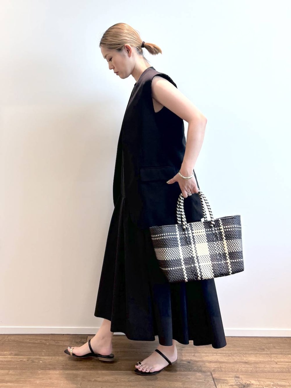その他のトートバッグ、ブラック系のワンピース、ブラック系のベストを着用したレディースの春コーディネートの2枚目の写真