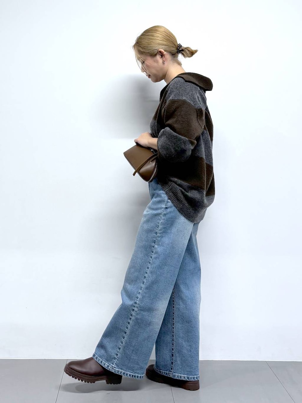 ブルー系のデニムパンツ、ブラウン系のニット/セーター、ブラウン系のショルダーバッグを着用したレディースの秋コーディネートの5枚目の写真