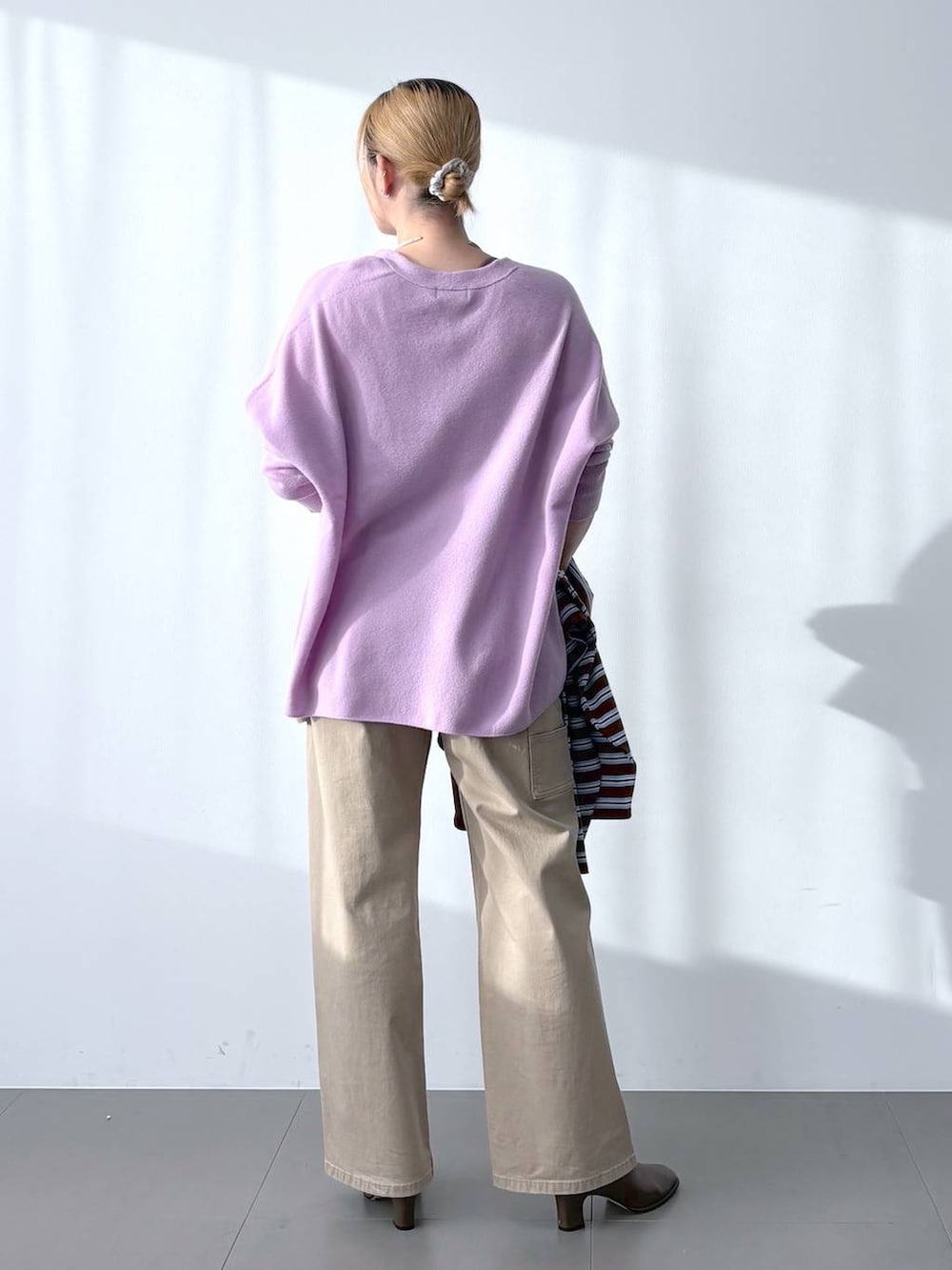 ブラウン系のブーツ、パープル系のニット/セーター、ブラウン系のTシャツ/カットソーを着用したレディースの冬コーディネートの6枚目の写真