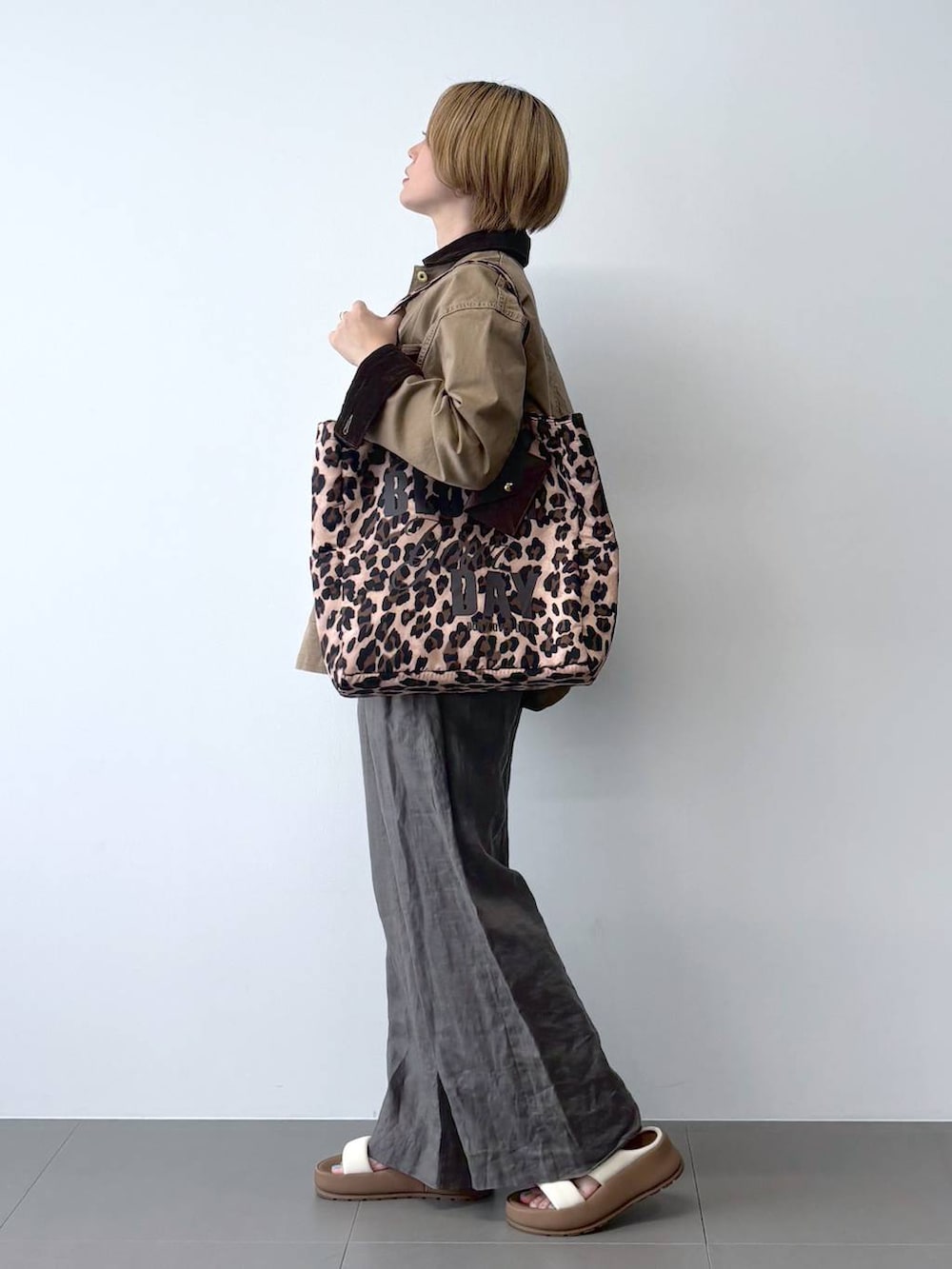 ベージュ系のミリタリージャケット、グリーン系のその他パンツ、その他のトートバッグを着用したレディースの春コーディネートの2枚目の写真