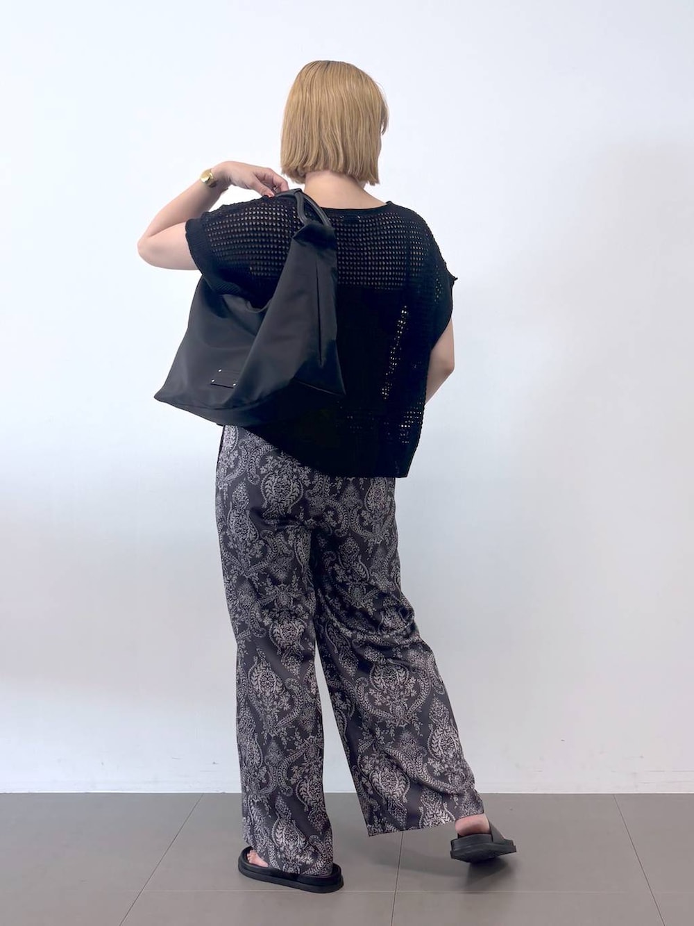 ブラック系のキャミソール、ブラック系のニット/セーター、グレー系のその他パンツを着用したレディースの春コーディネートの7枚目の写真
