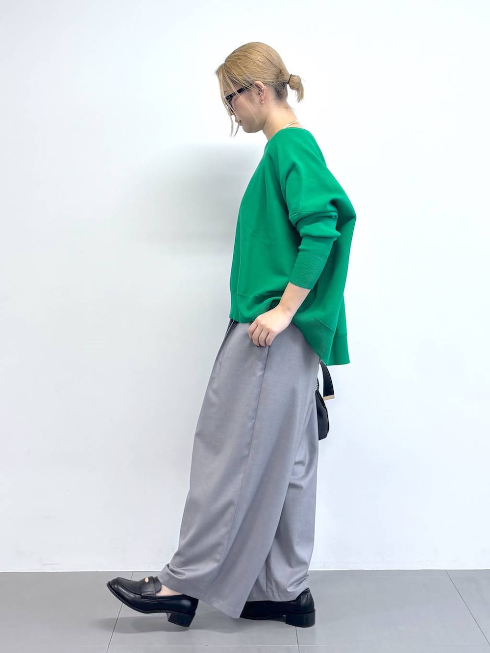 グリーン系のニット/セーター、グレー系のその他パンツ、その他のショルダーバッグを着用したレディースの冬コーディネートの3枚目の写真