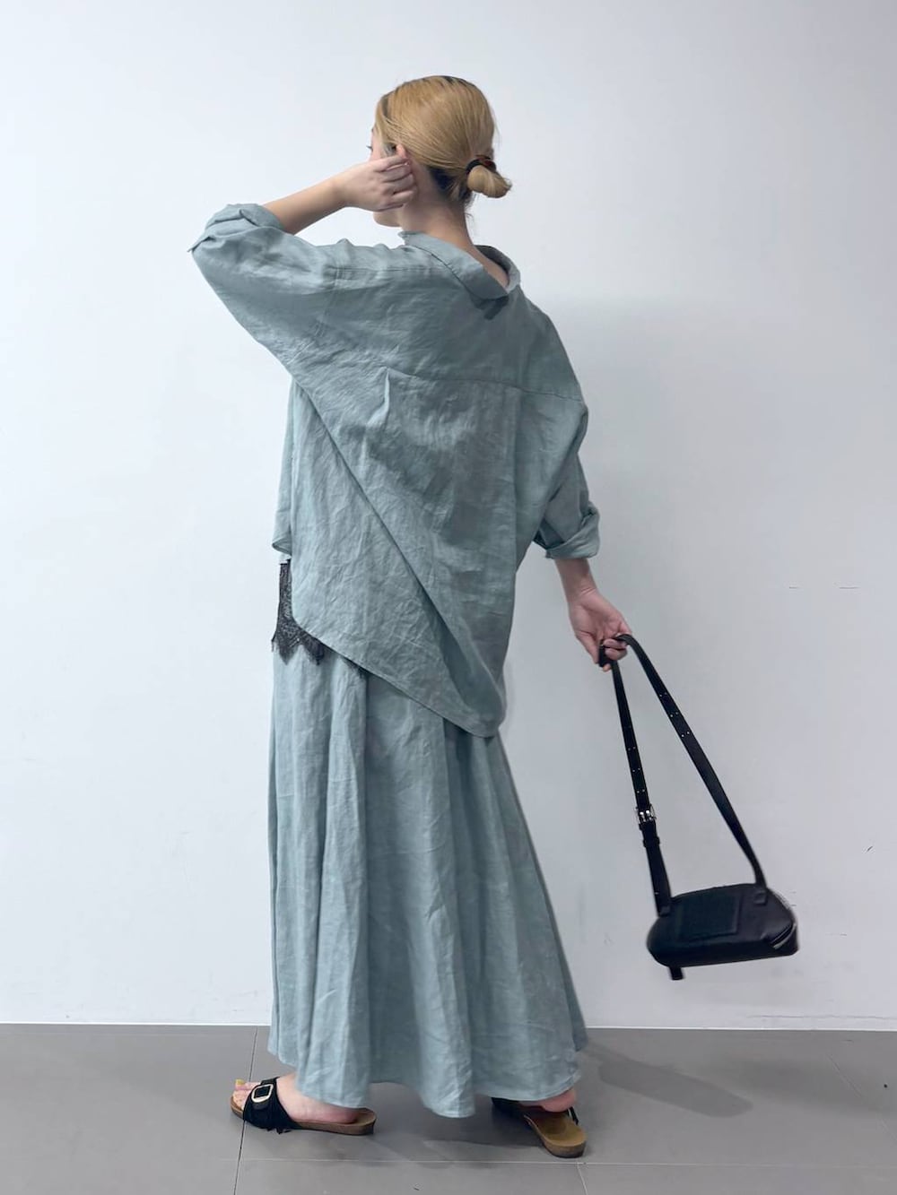 グリーン系のシャツ/ブラウス、グリーン系のスカート、ブラック系のショルダーバッグを着用したレディースの春コーディネートの4枚目の写真