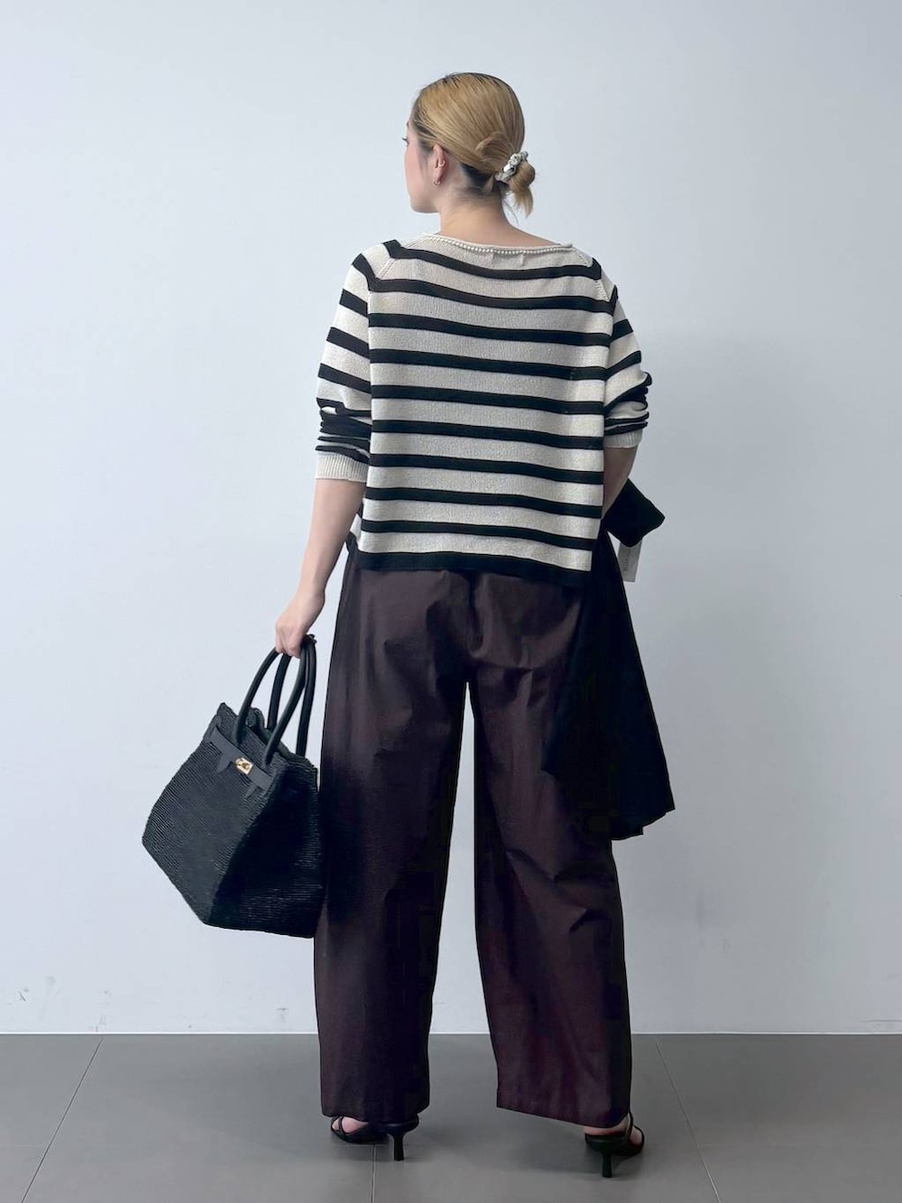 ブラウン系のその他パンツ、ベージュ系のニット/セーター、ブラック系のテーラードジャケットを着用したレディースの春コーディネートの5枚目の写真