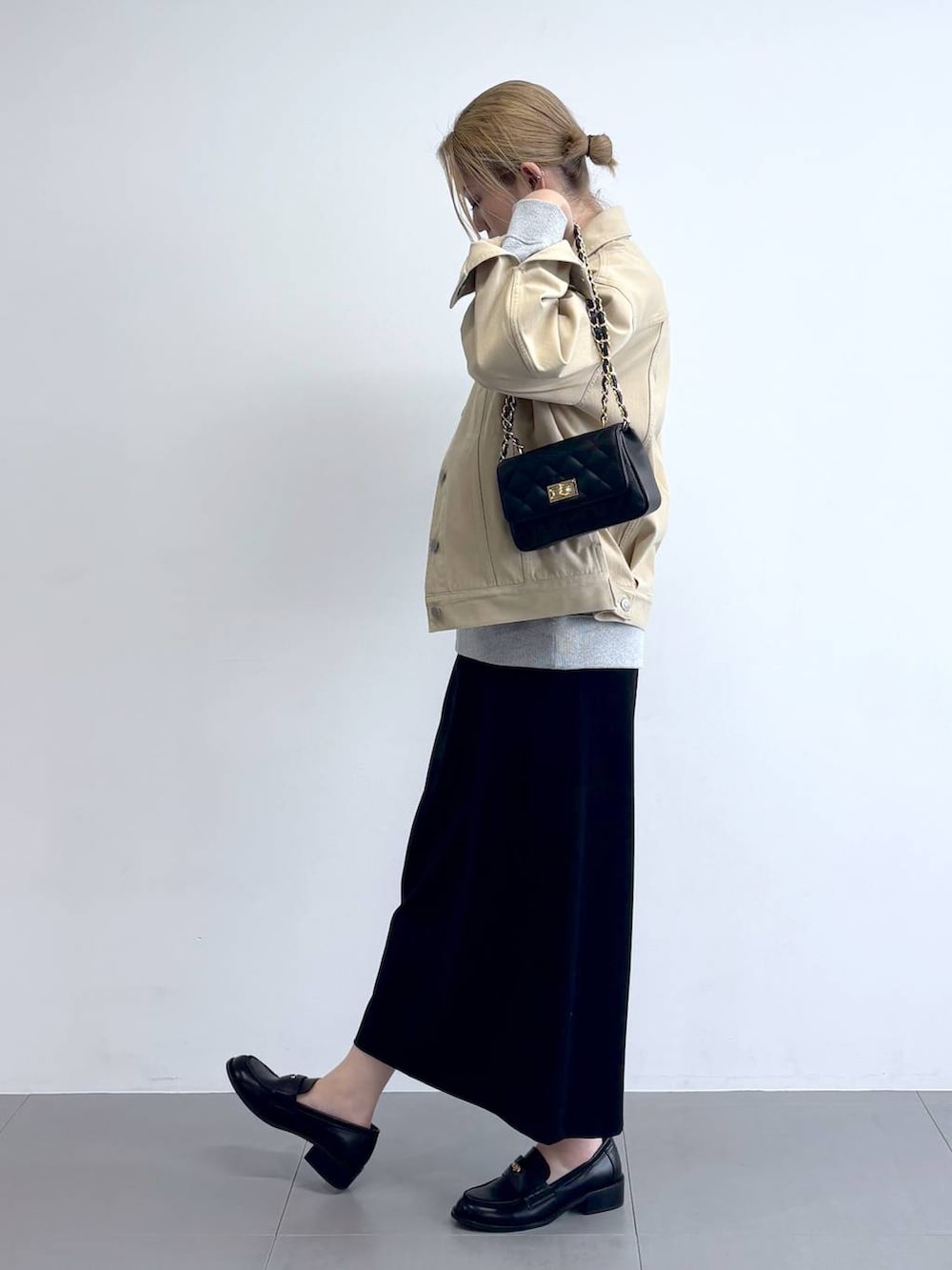 ベージュ系のデニムジャケット、グレー系のスウェット、ブラック系のスカートを着用したレディースの冬コーディネートの3枚目の写真